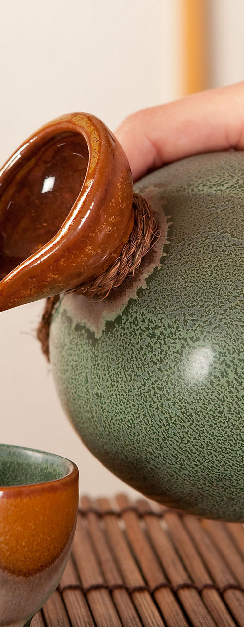 Traditional sake pouring in ceramic cups