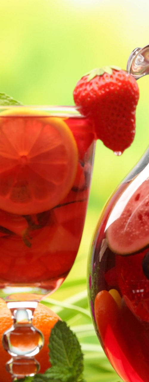 Refreshing fruit punch in glass and pitcher