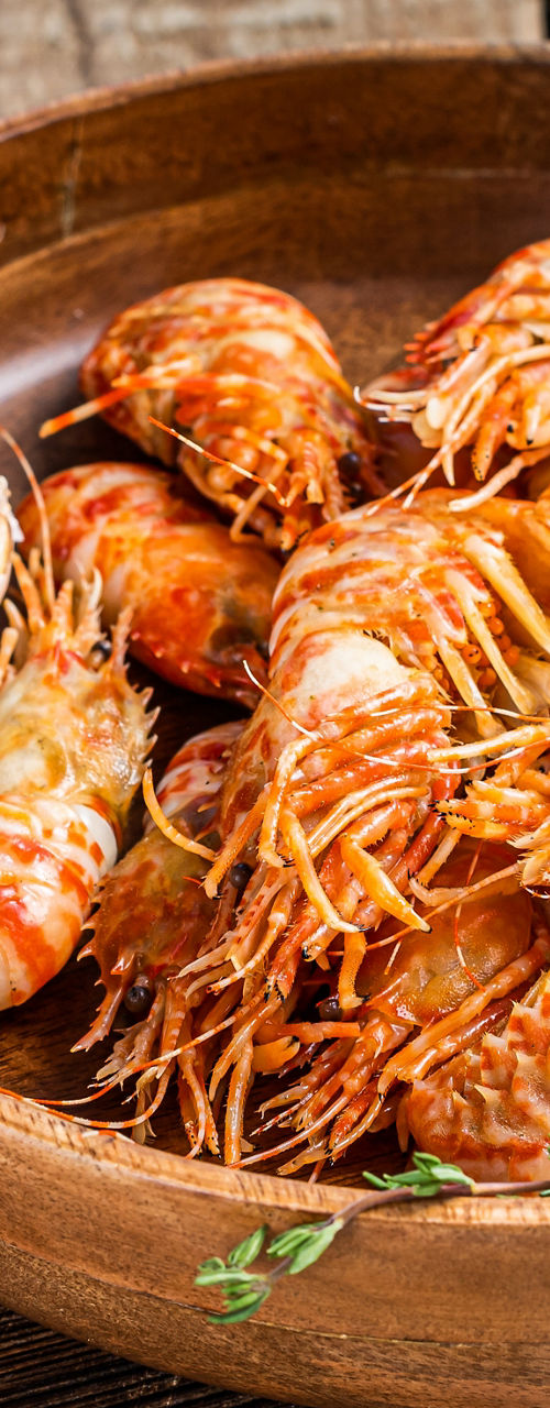 Wooden Bowl of Cooked Shrimp with Herbs