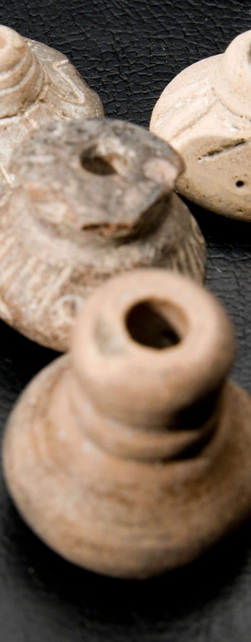 Handcrafted clay oil lamps on black surface