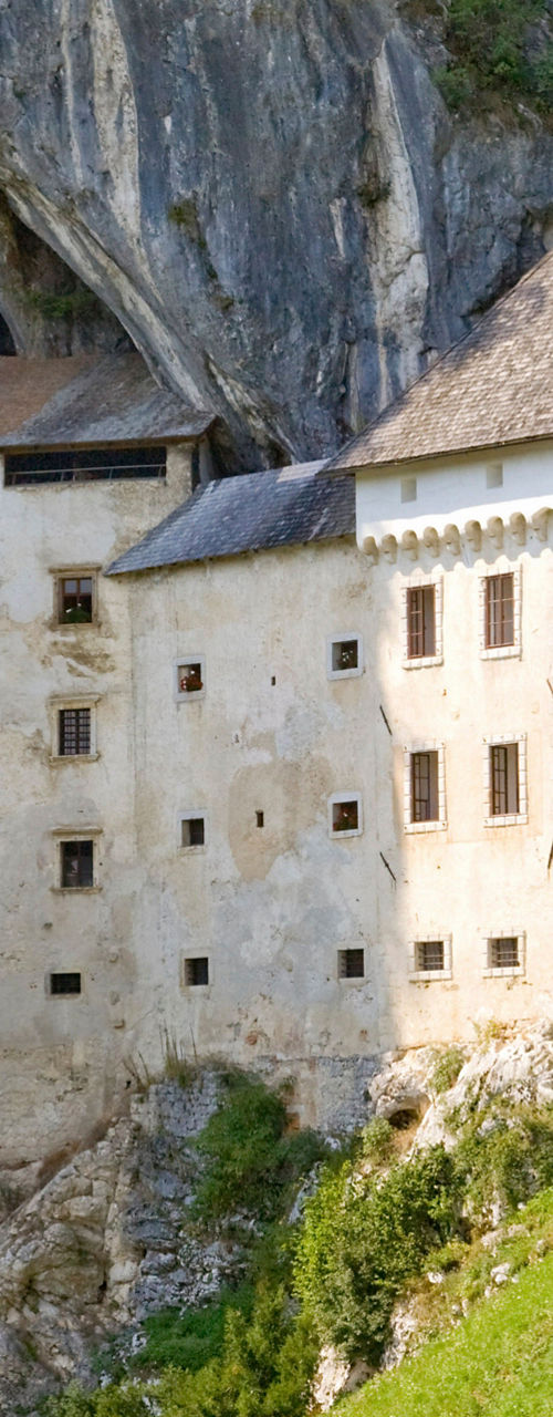 Historic cliffside castle with colorful flags