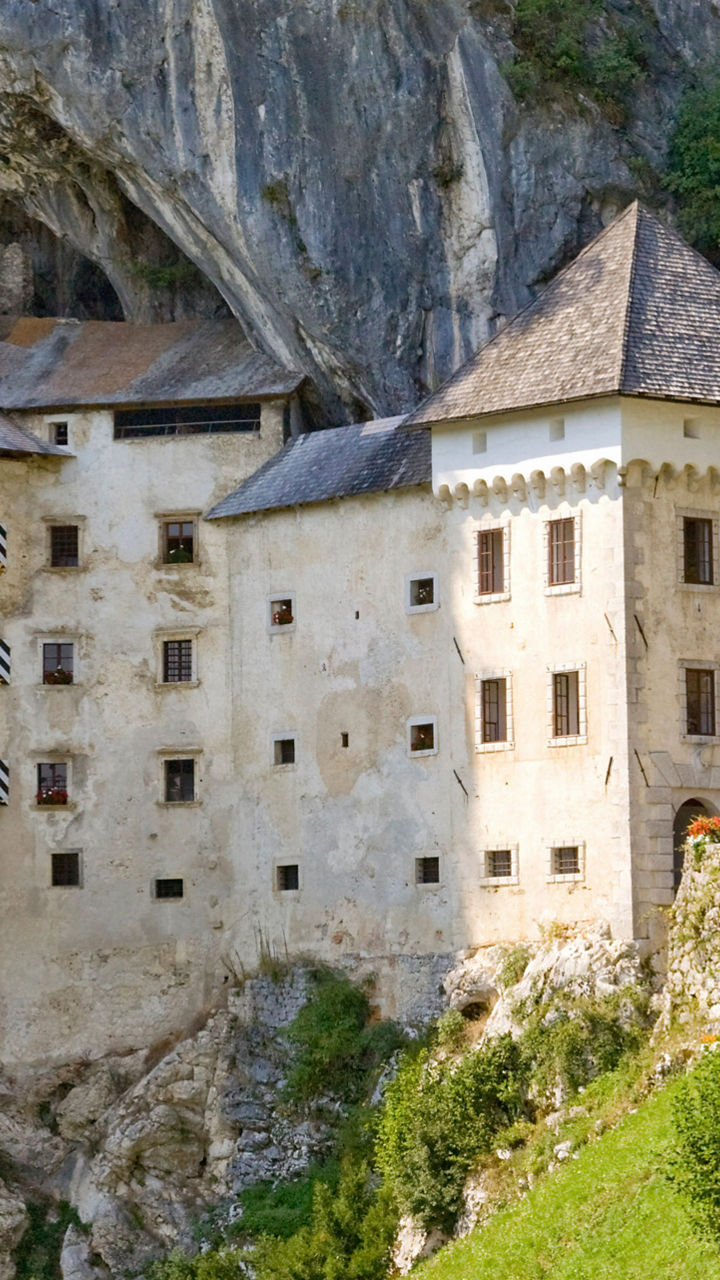 Historic cliffside castle with colorful flags