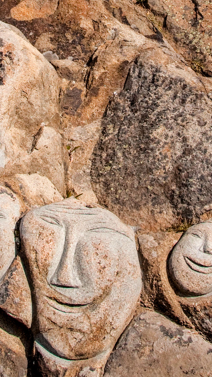 Carved stone faces on rocky cliff
