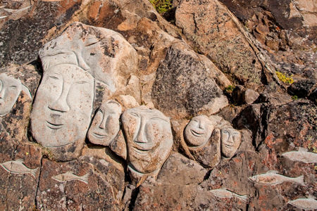 Carved stone faces on rocky cliff