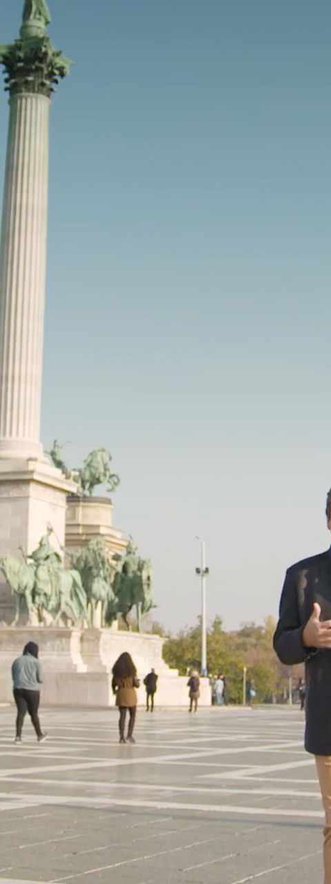 Man Standing in Front of Historic City Monument