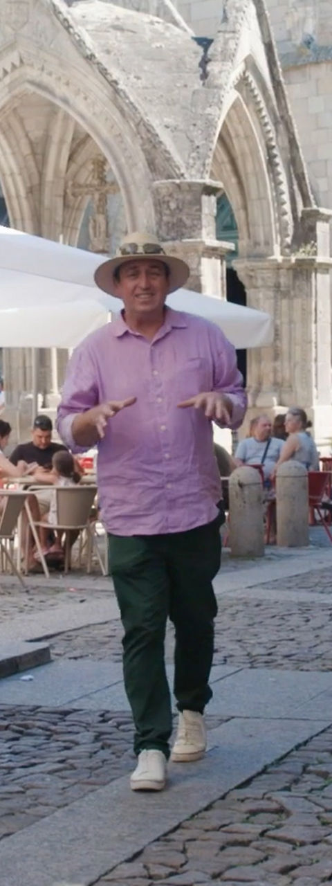 Man in hat walks through historic European square