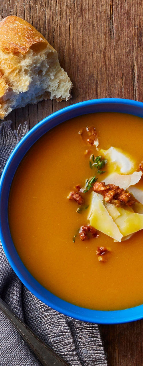 Rustic soup with bread on wooden table