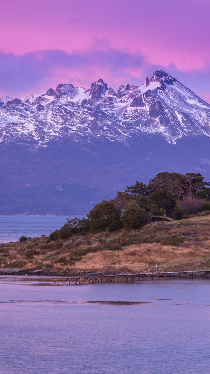 Snow-capped mountains under vibrant purple sky