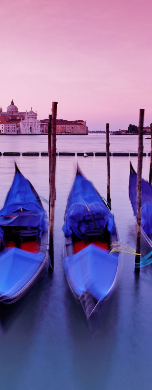 Venetian gondolas at sunset with pink sky