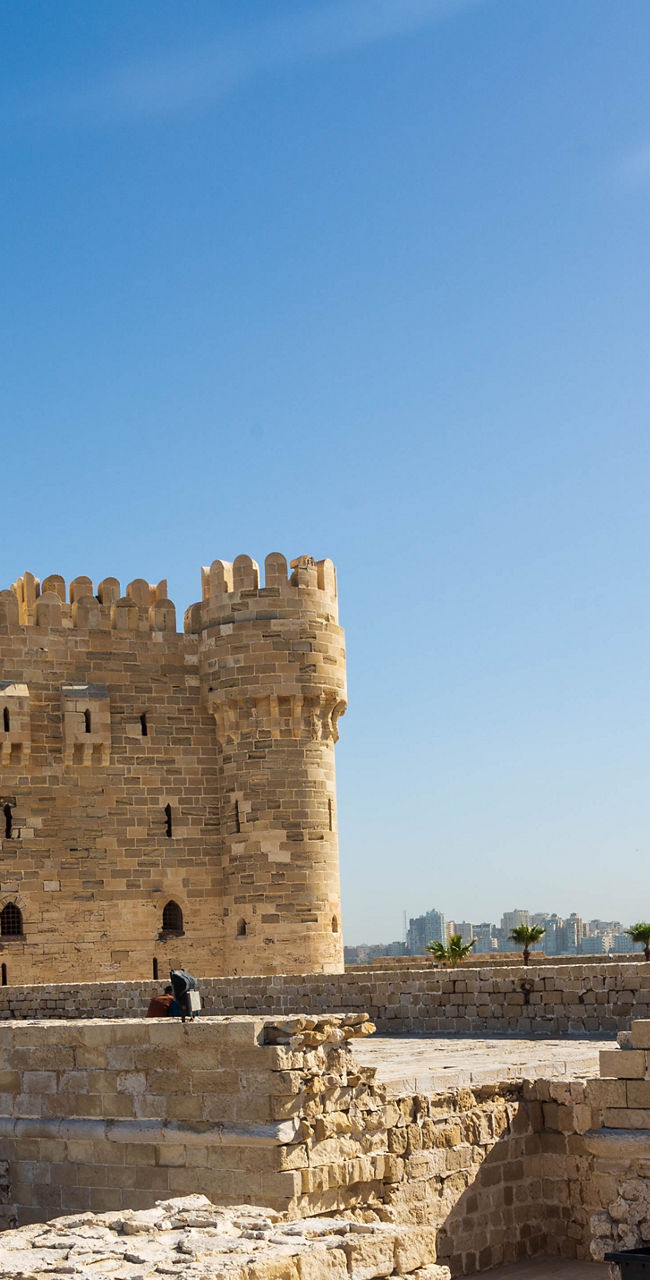 Historic fortress with Egyptian flag in sunlight