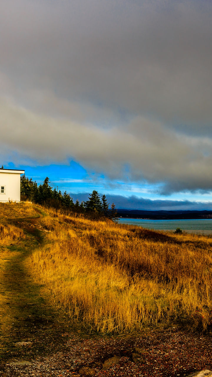 Coastal lighthouse under dramatic cloudy sky