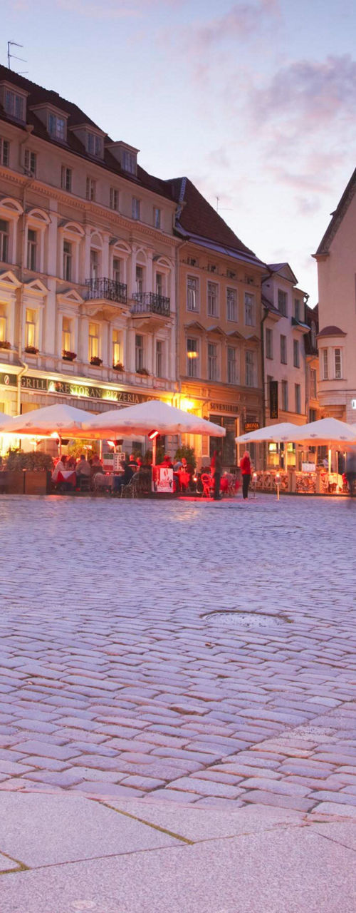 Evening city square with cyclist and cafes