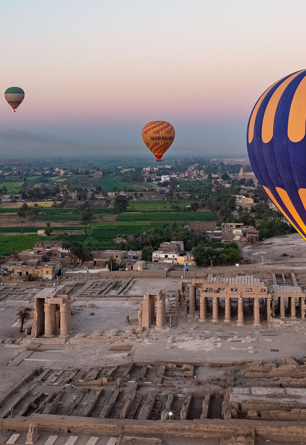 Hot air balloons over ancient ruins at sunrise