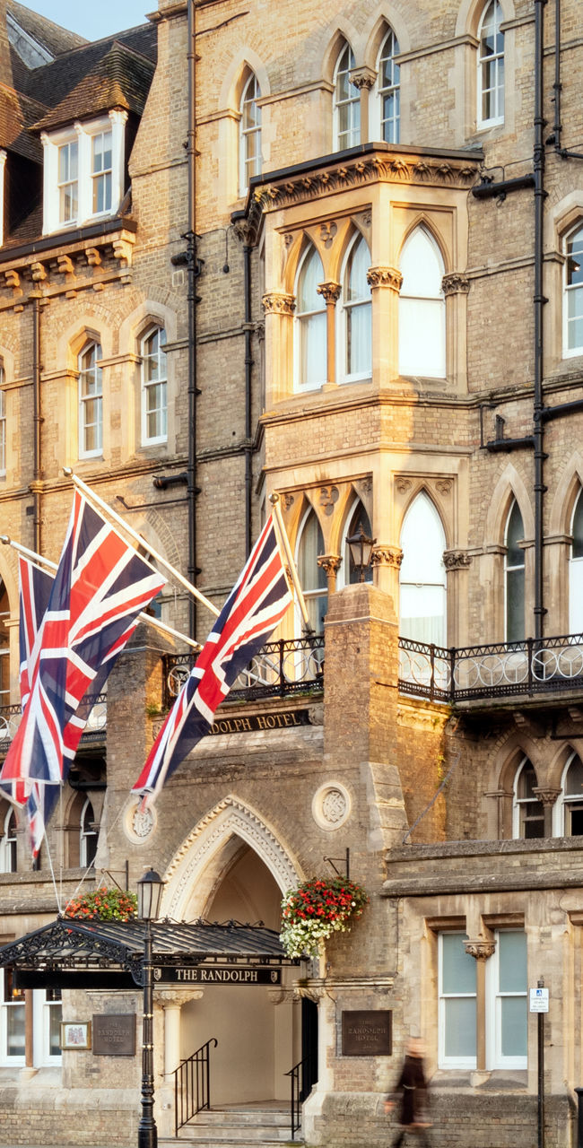 Historic stone building with British flags on city street