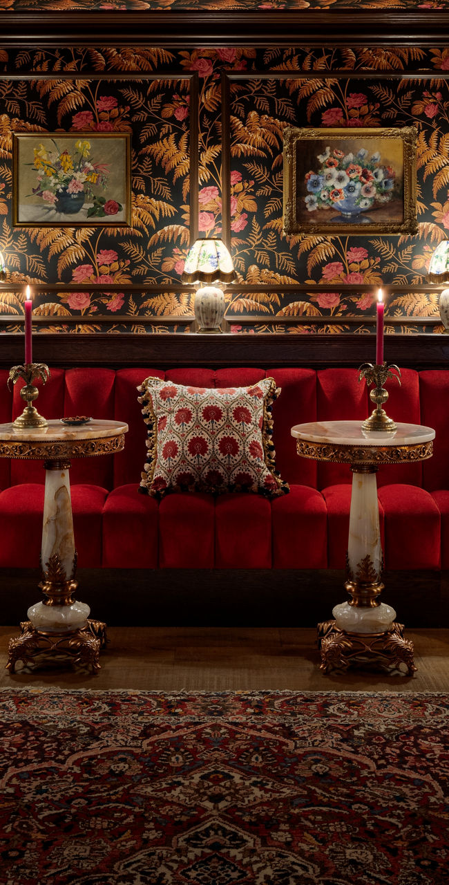Elegant vintage lounge with floral wallpaper and red velvet seating