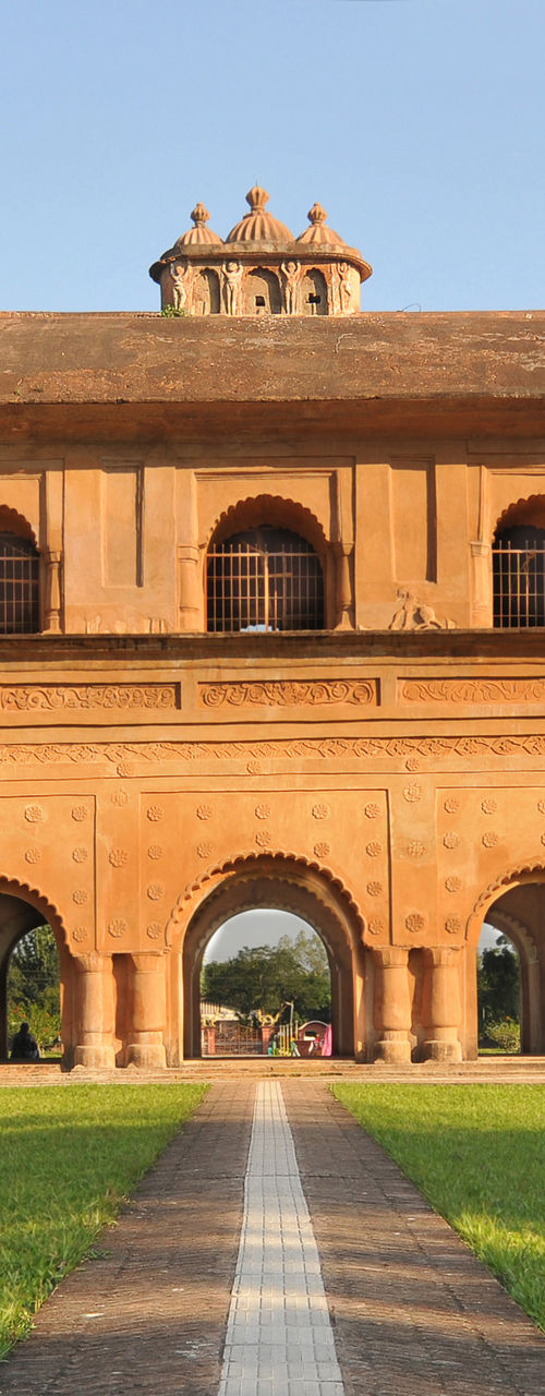 Historic red brick building in lush setting
