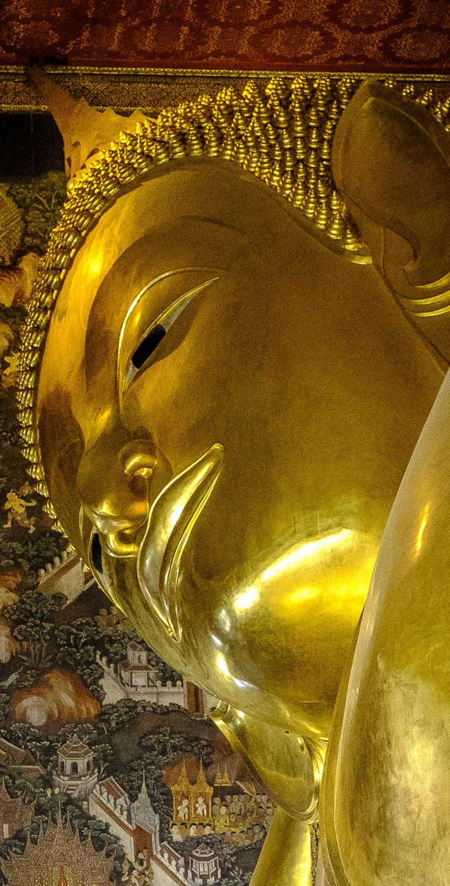 Golden reclining Buddha in ornate temple