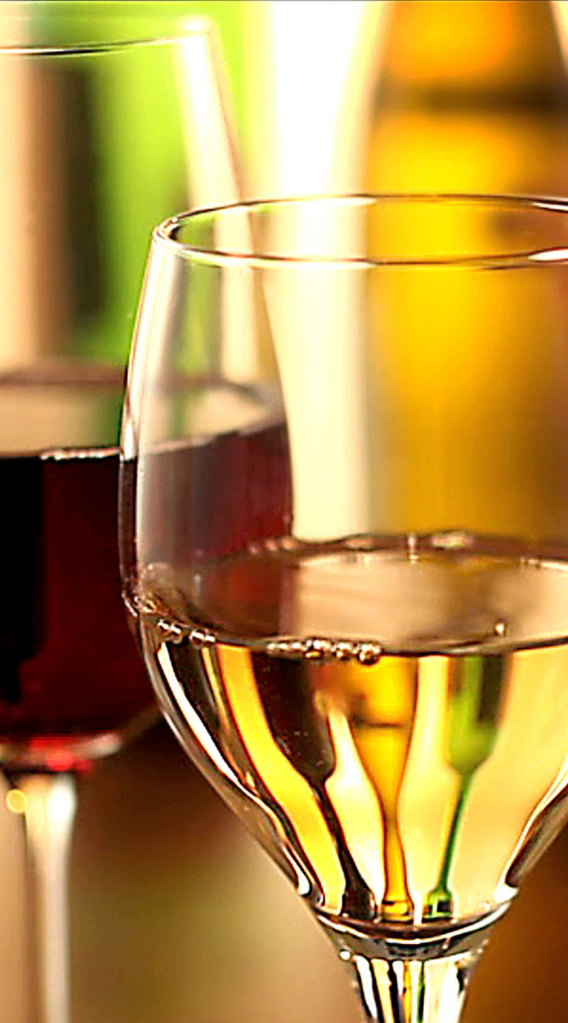 Red and white wine glasses in warm light