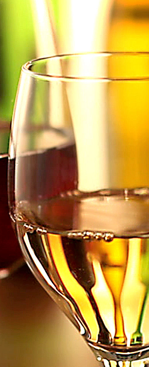 Red and white wine glasses in warm light
