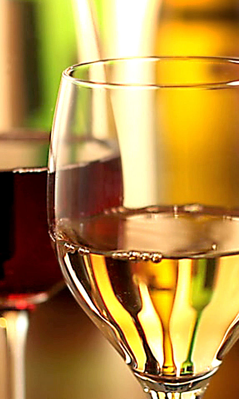 Red and white wine glasses in warm light