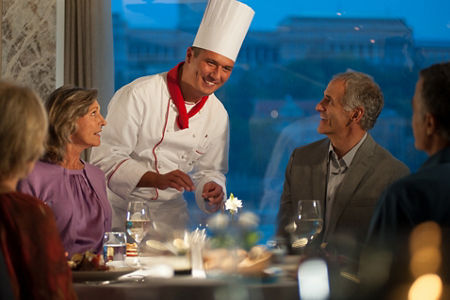 Chef serving guests at elegant dinner