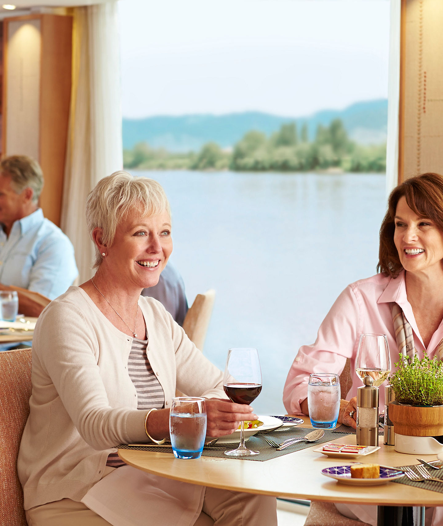 Group dining in scenic riverside restaurant setting