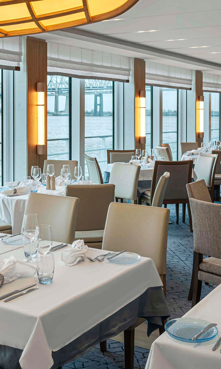 Elegant waterfront dining room with large windows