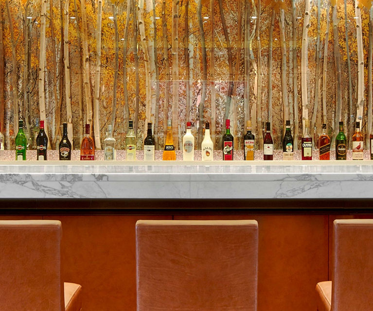 Modern bar with leather stools and backlit shelves