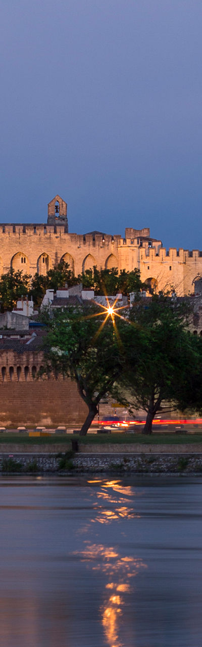 Historic castle by river at dusk