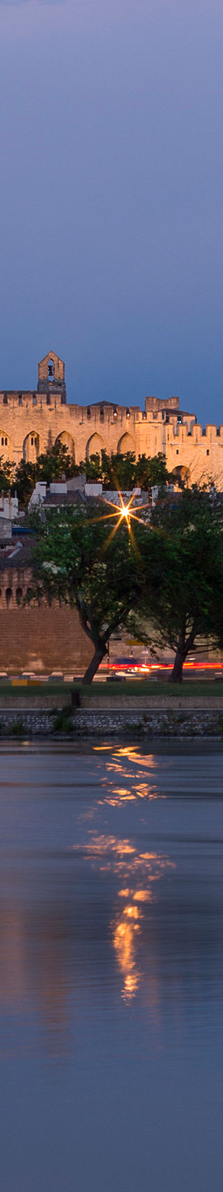 Historic castle by river at dusk