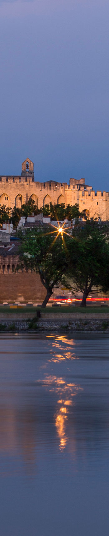 Historic castle by river at dusk
