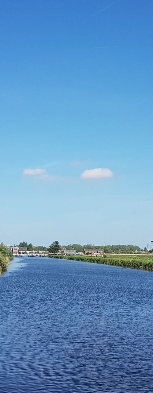 Traditional windmill by serene river landscape