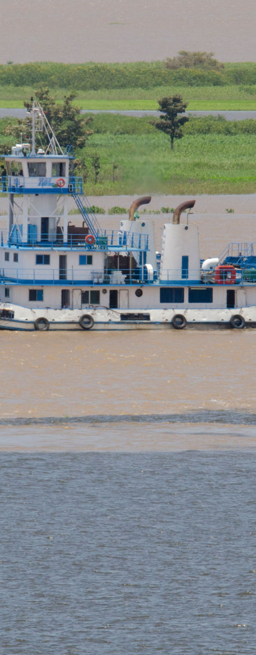 Blue ferry and small boat on river