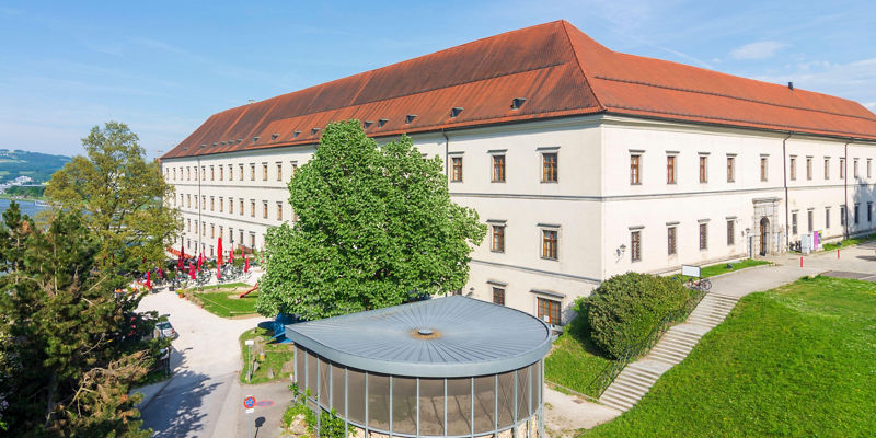 Historic building with red roof and river view
