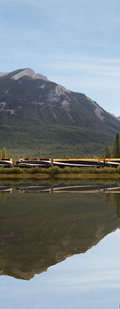 Train crossing scenic mountain lake view