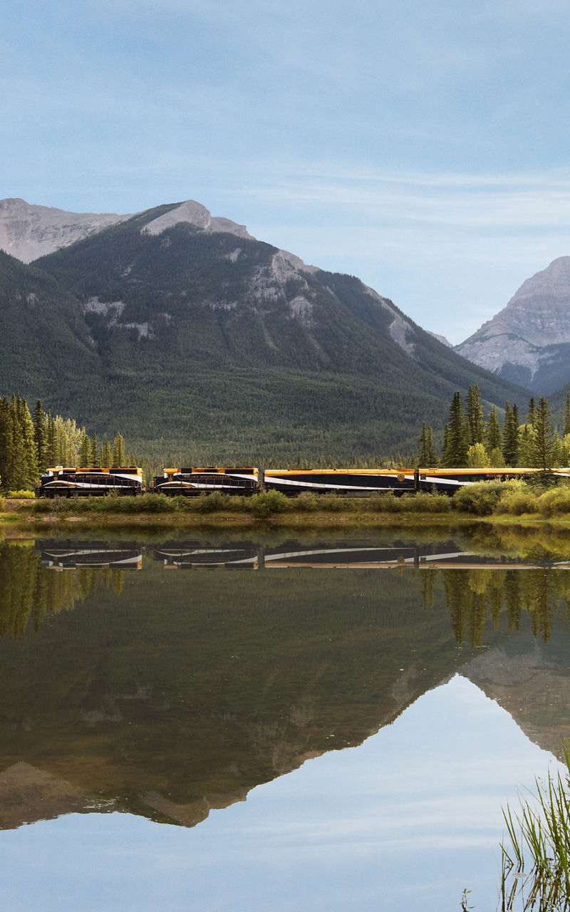 Train crossing scenic mountain lake view