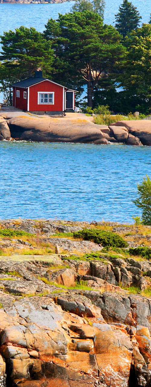 Scenic coastal view with red cabin