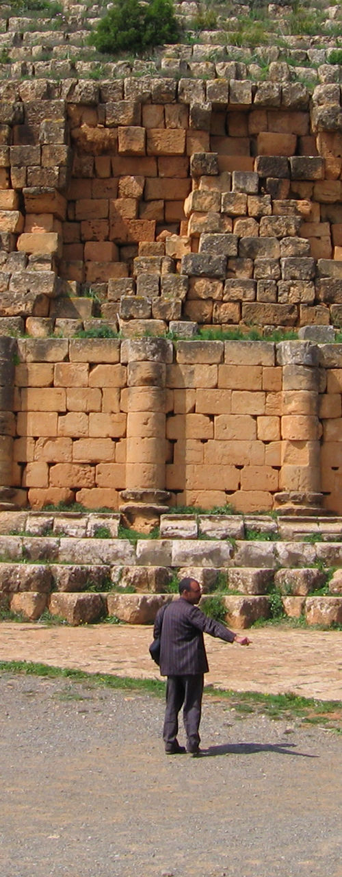 Ancient stone mausoleum with visitors and horse