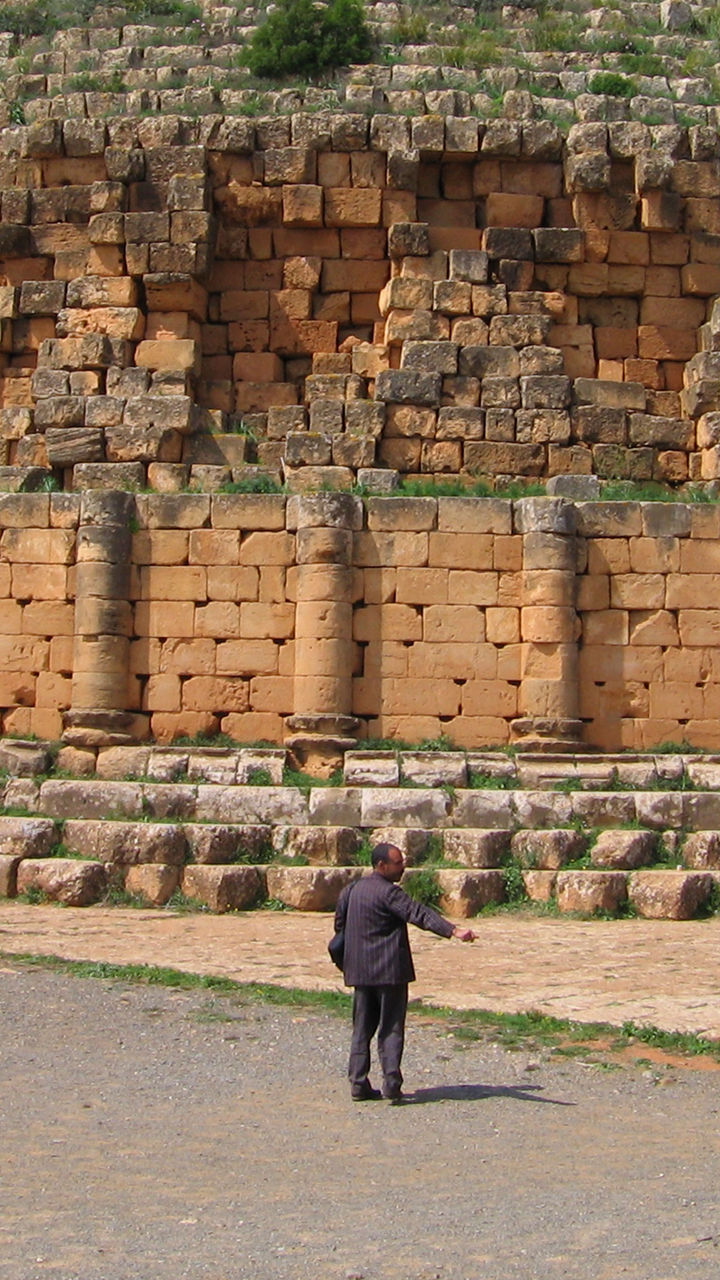 Ancient stone mausoleum with visitors and horse