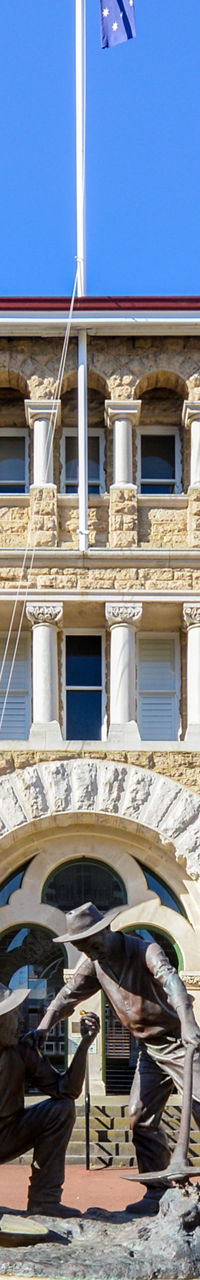 Historic stone building with statue centerpiece