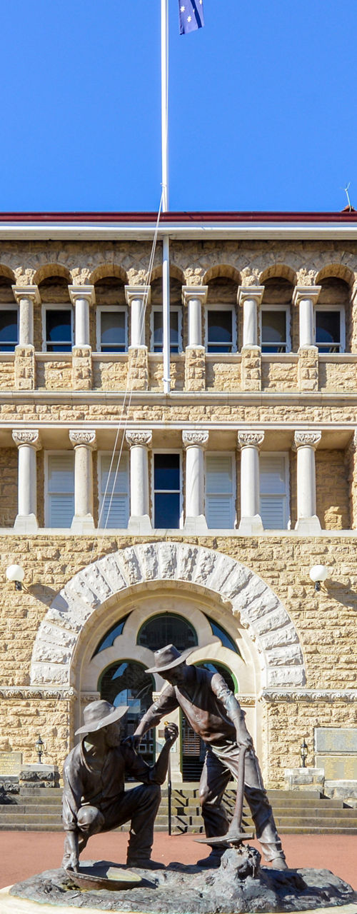 Historic stone building with statue centerpiece