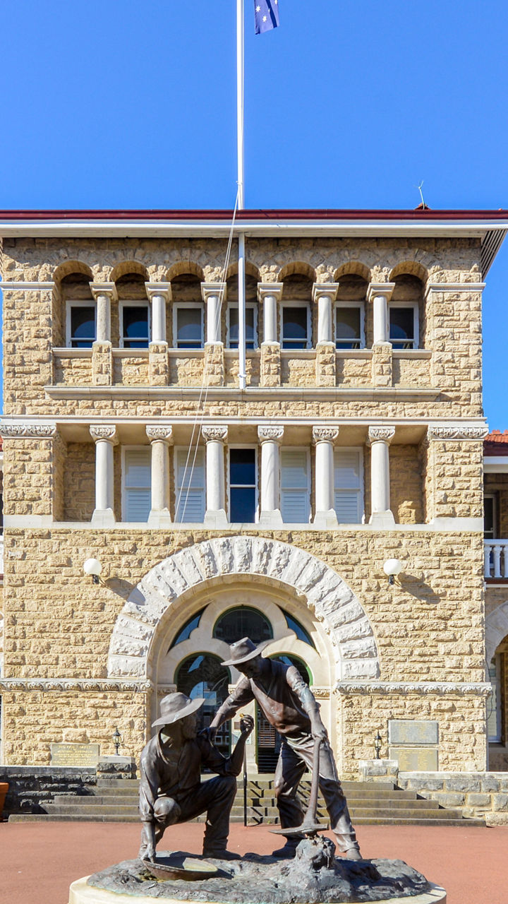 Historic stone building with statue centerpiece