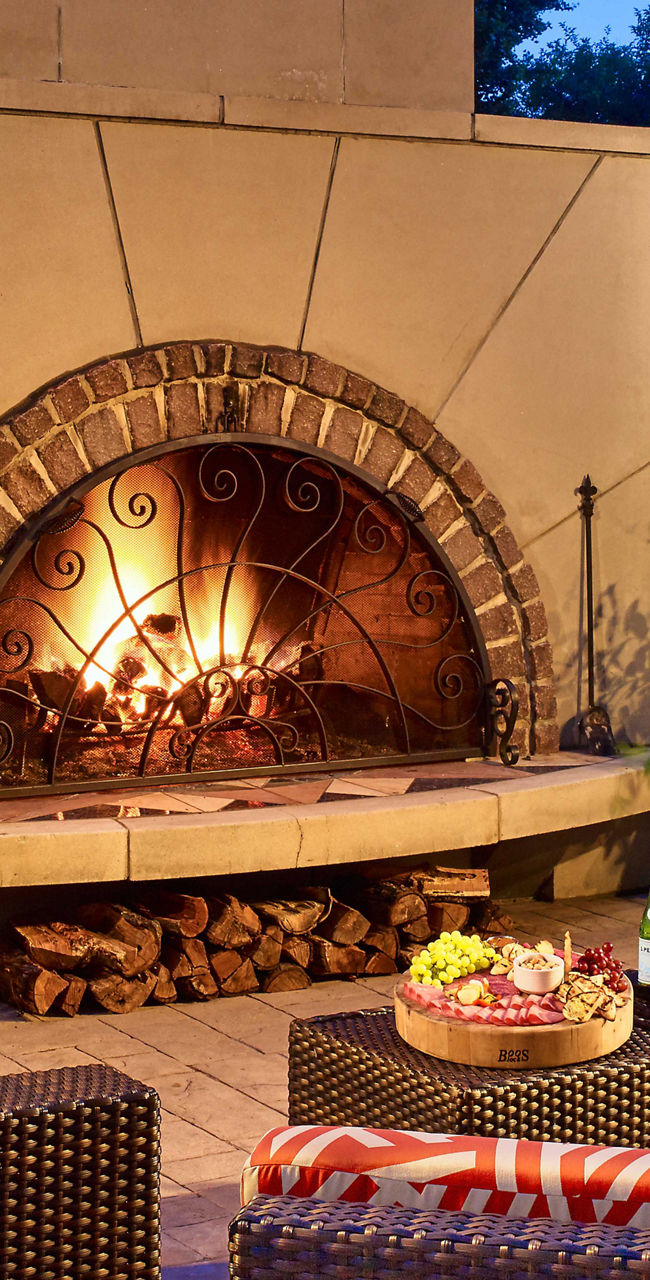 Cozy outdoor patio with glowing fireplace