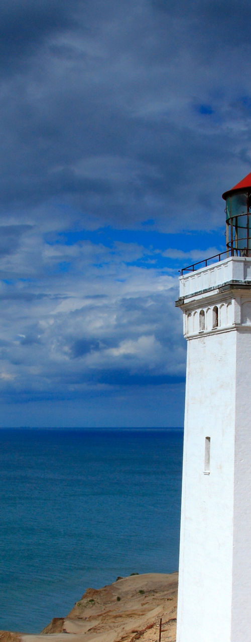 White lighthouse on coastal sand dunes
