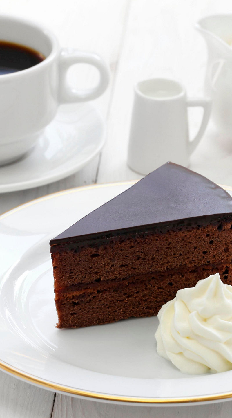 Chocolate cake slice with coffee and cream