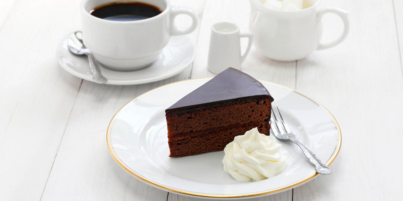 Chocolate cake slice with coffee and cream