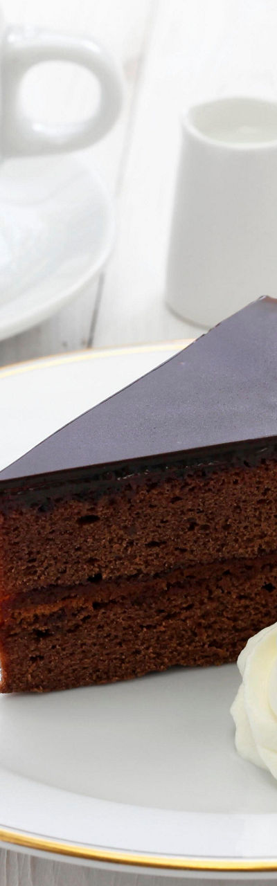 Chocolate cake slice with coffee and cream