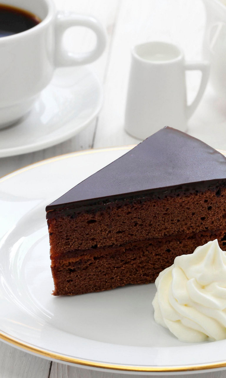 Chocolate cake slice with coffee and cream