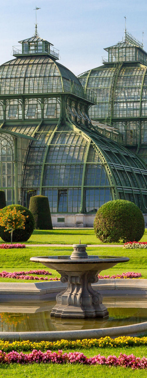 Historic glass greenhouse with manicured gardens