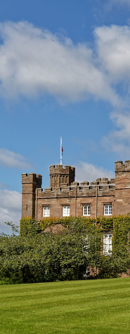 Historic stone castle on sunny green lawn